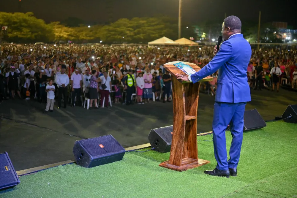 Minister addressing a large outdoor crusade